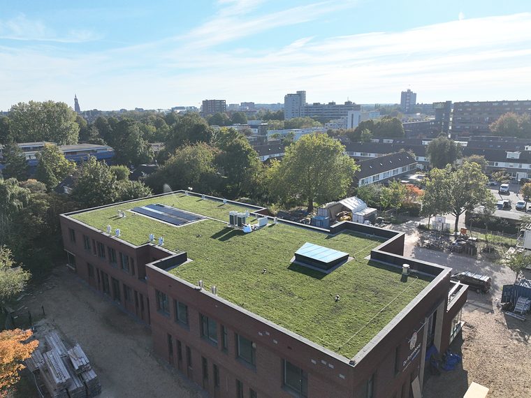 Bakstenen gebouw met een sedumdak en lichtkoepels
